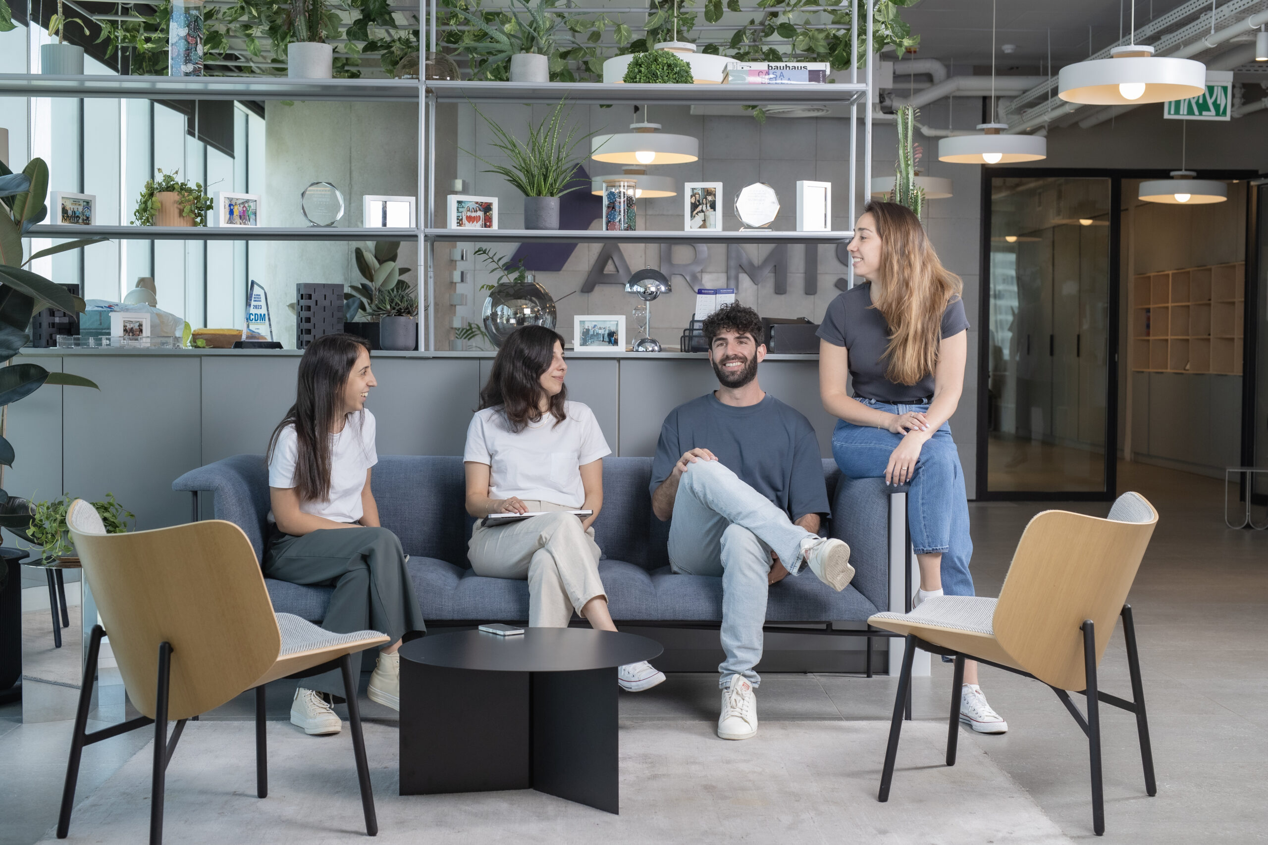 Armis employees sitting on couch in lounge